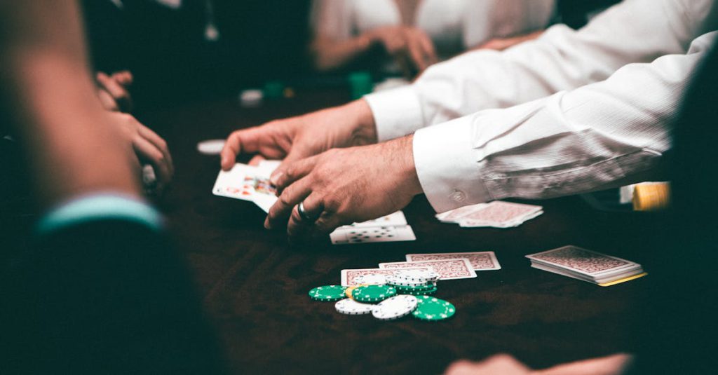 An intense poker game featuring players and poker chips on the table in an indoor setting.